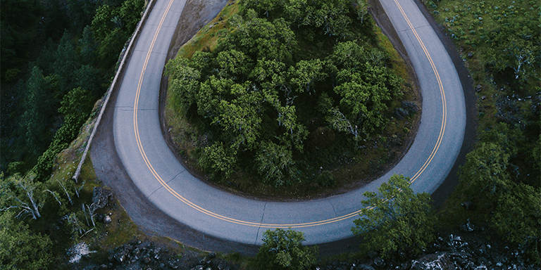 Overhead view of a sharp turn on a road in the mountains