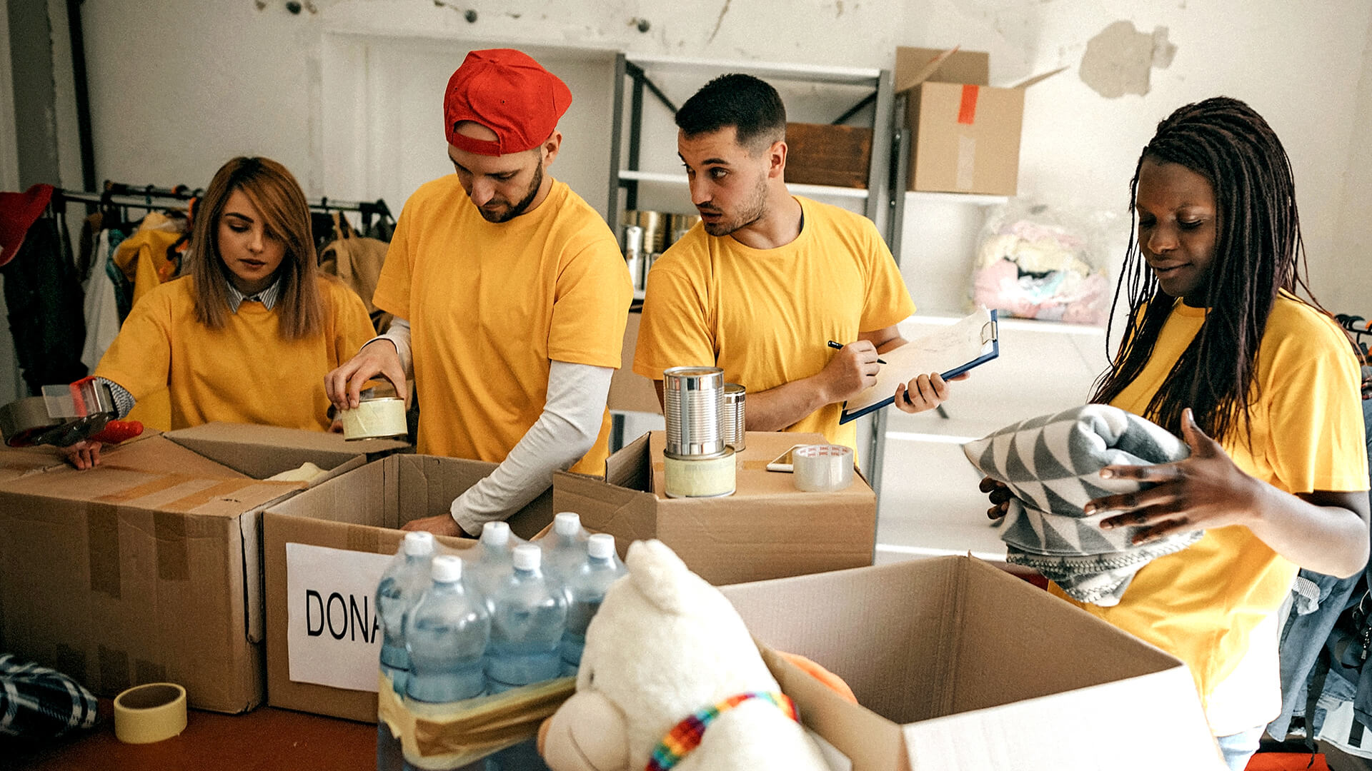 A group of volunteers wearing yellow shirts working at a donation center