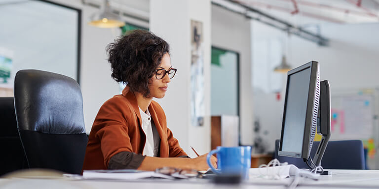 A young woman working at her desk in her office 