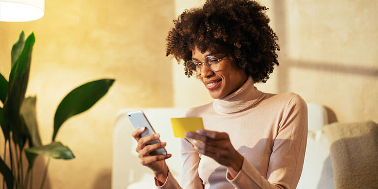 Woman copying something from a yellow piece of paper onto her phone