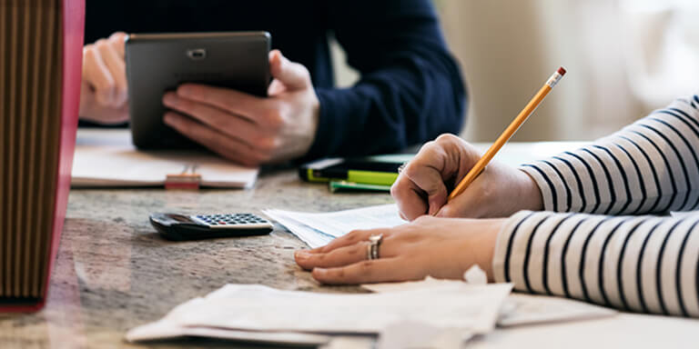 A couple working on taxes together in their kitchen.