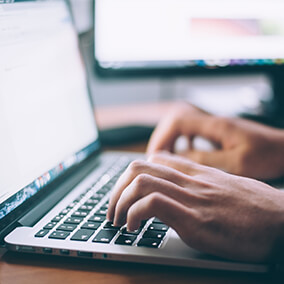 Close up of hands typing on a keyboard on a laptop computer