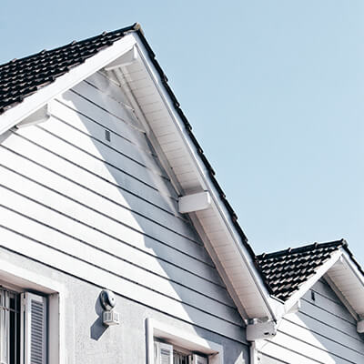 A house with white siding and a black shingled roof 