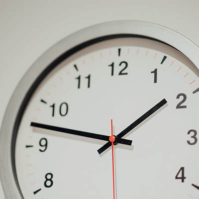 The face of a analog clock hanging on a wall 