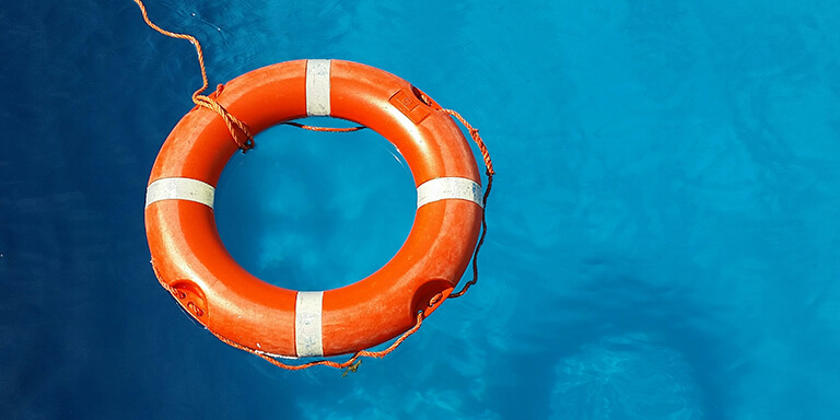 An orange life preserver floating in a blue pool 