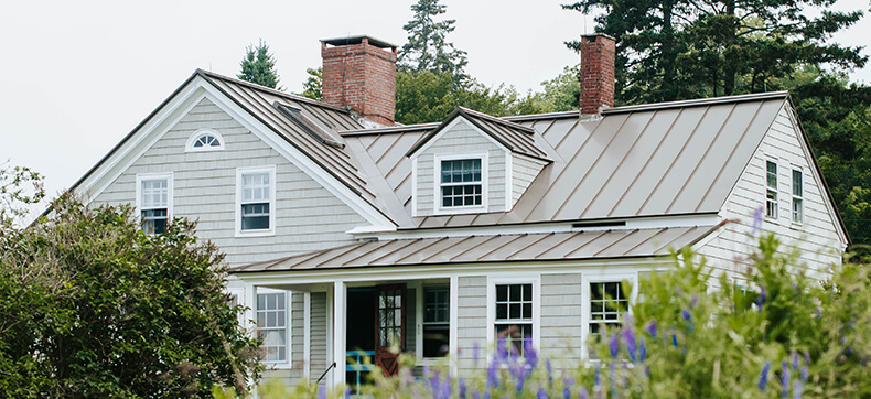 A cottage-style house surrounded my lavender and flowers