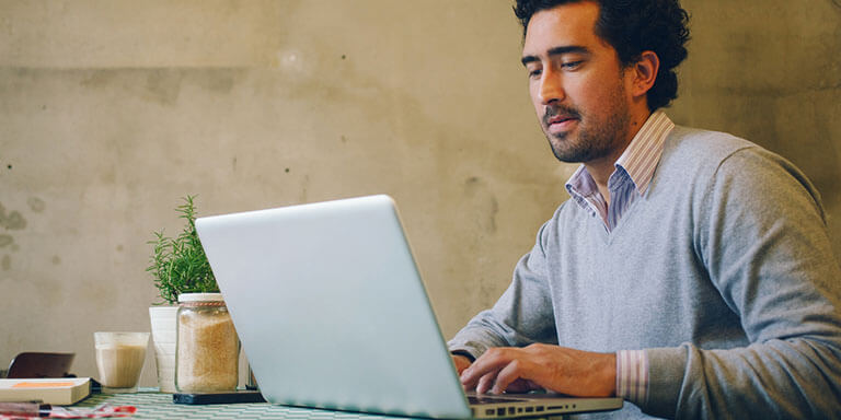 Young professional man working in a cafe on his laptop.