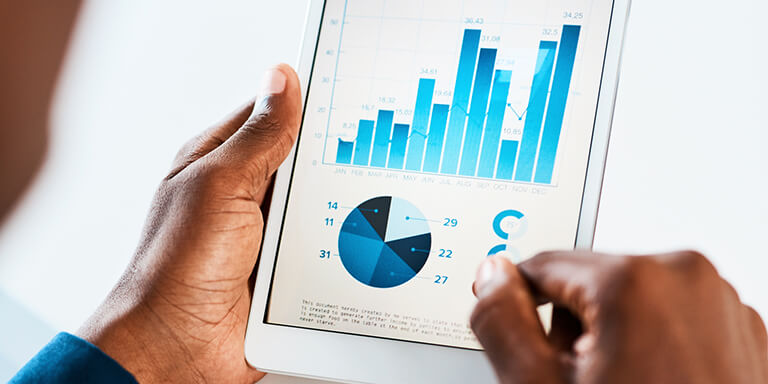 Man holding a tablet that shows a bunch of different kinds of graphs 