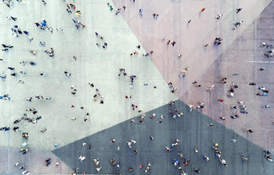 Arial view of people walking across colorful crosswalks in a city
