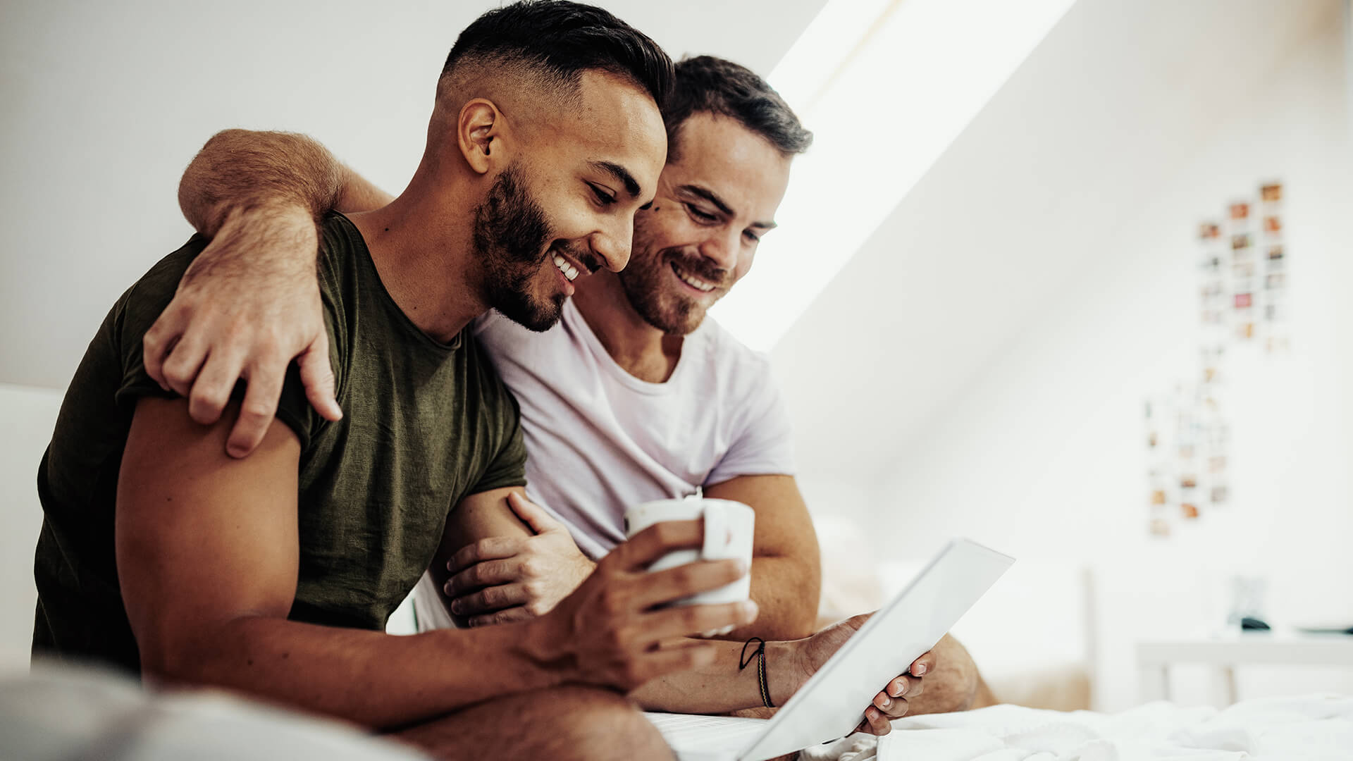 A couple sitting on the couch looking at a tablet together