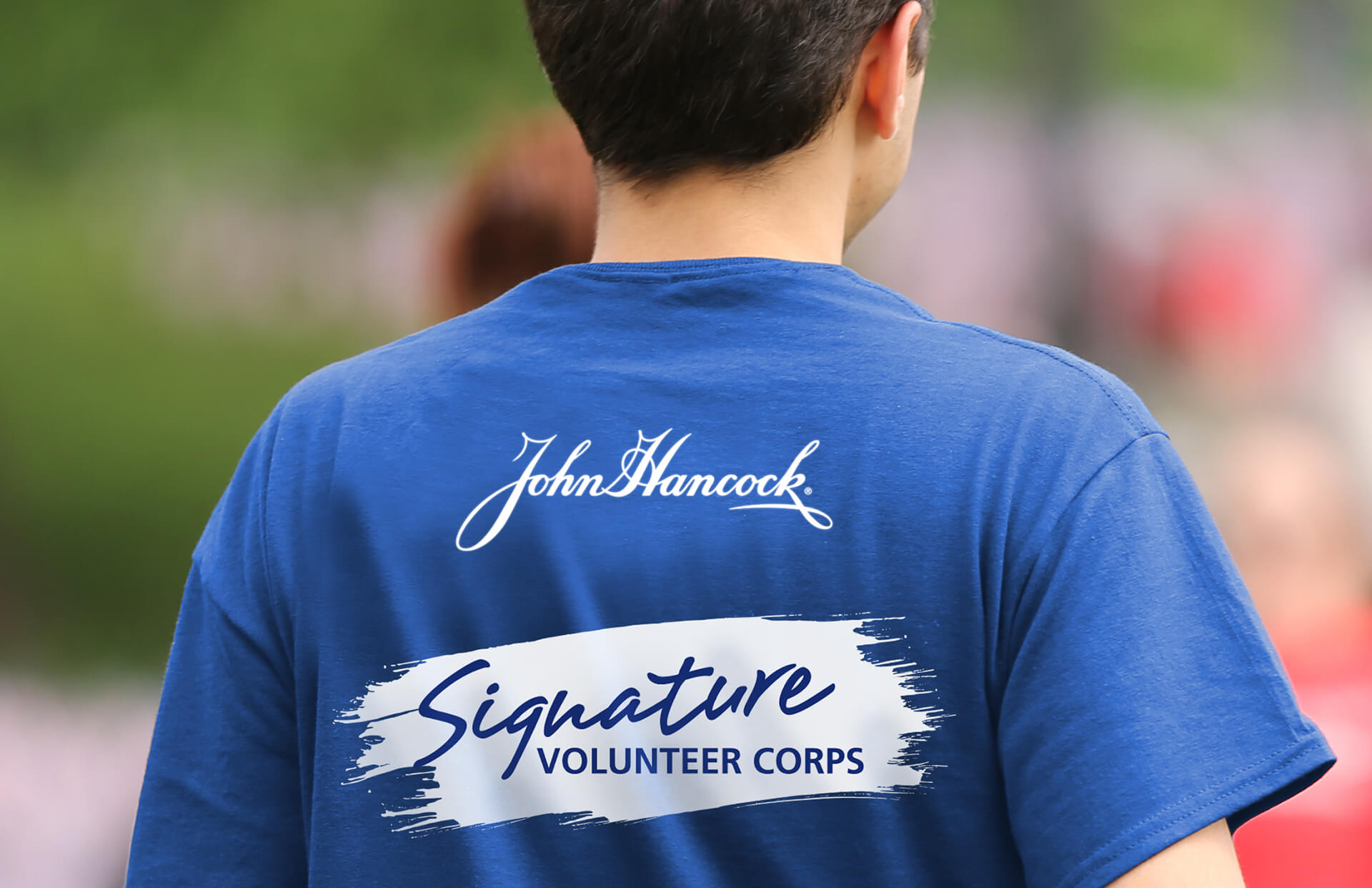 A John Hancock employee volunteer wearing a blue "Signature Volunteer Corps" t-shirt