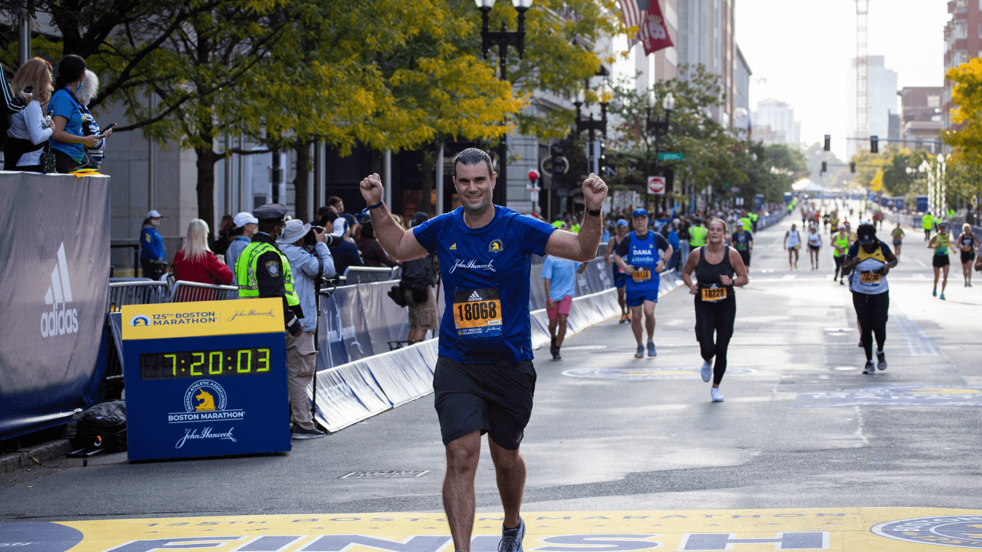 A John Hancock runner crossing the finish line at the 125th Boston Marathon