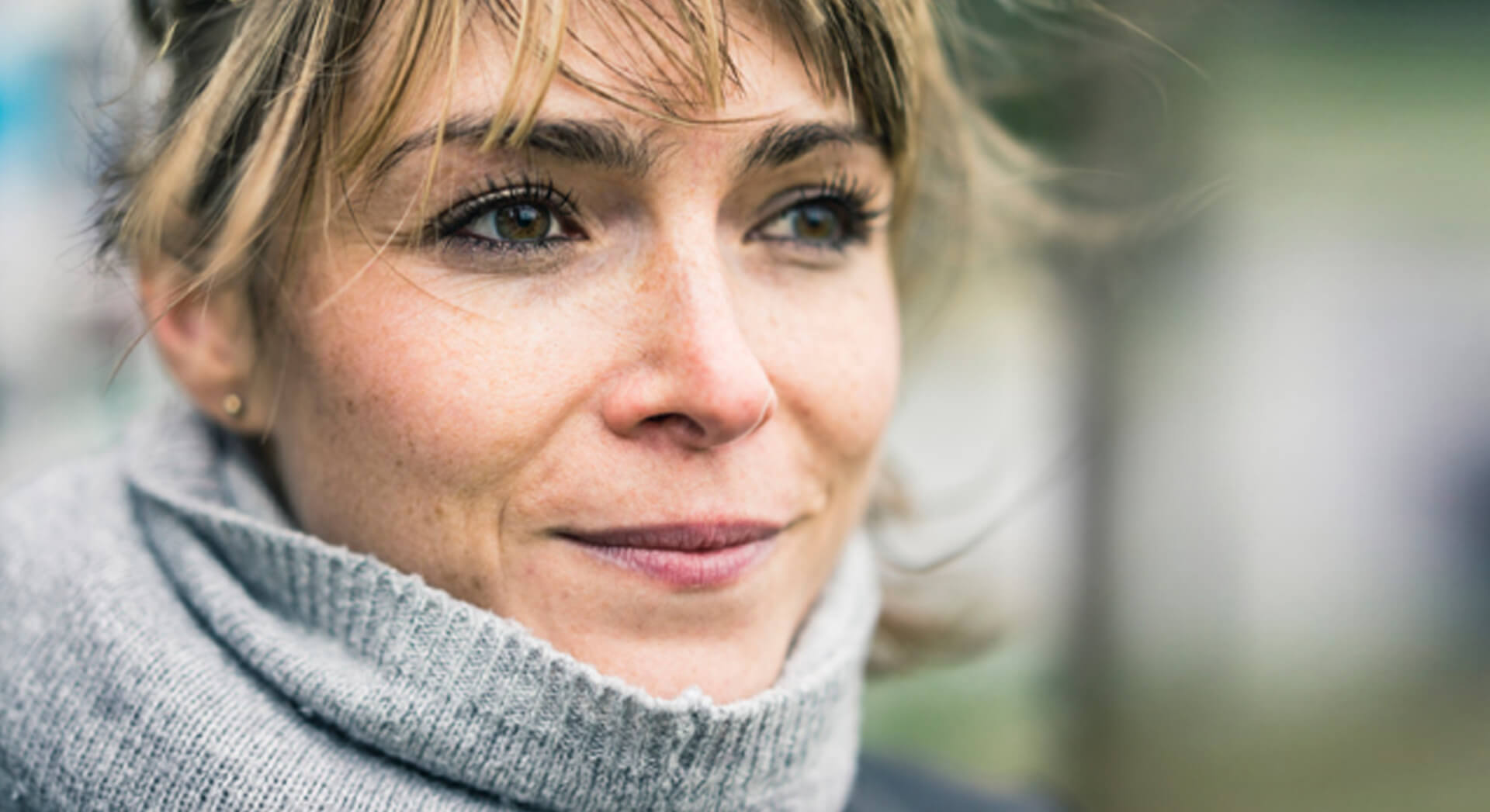 Close up of a woman outside with a large scarf draped around her neck