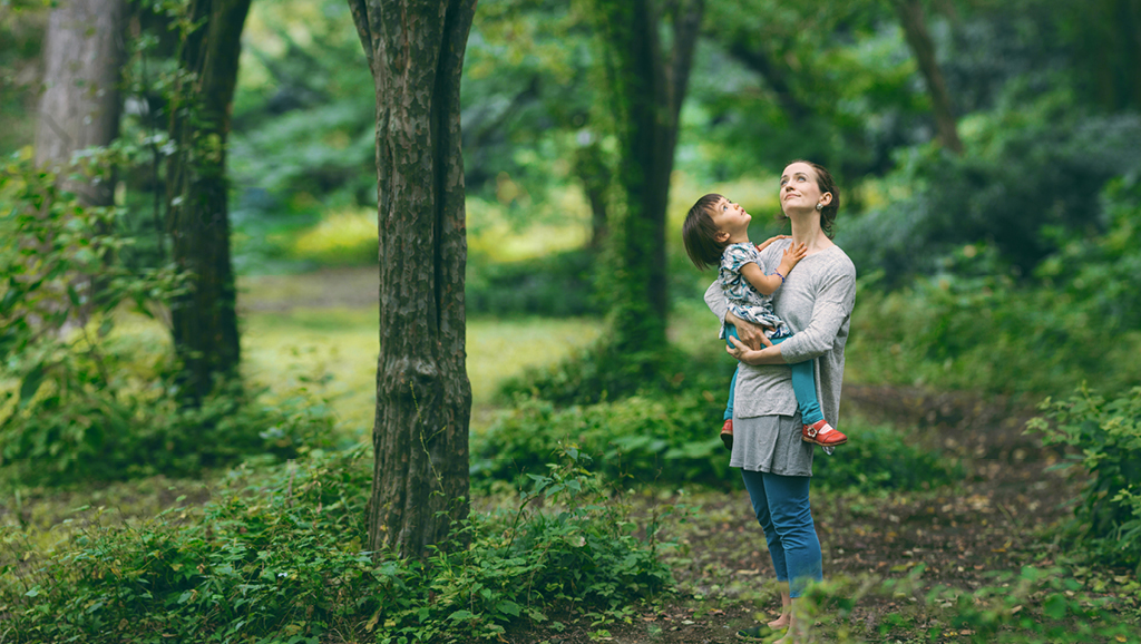Woman holding a child and looking to nature